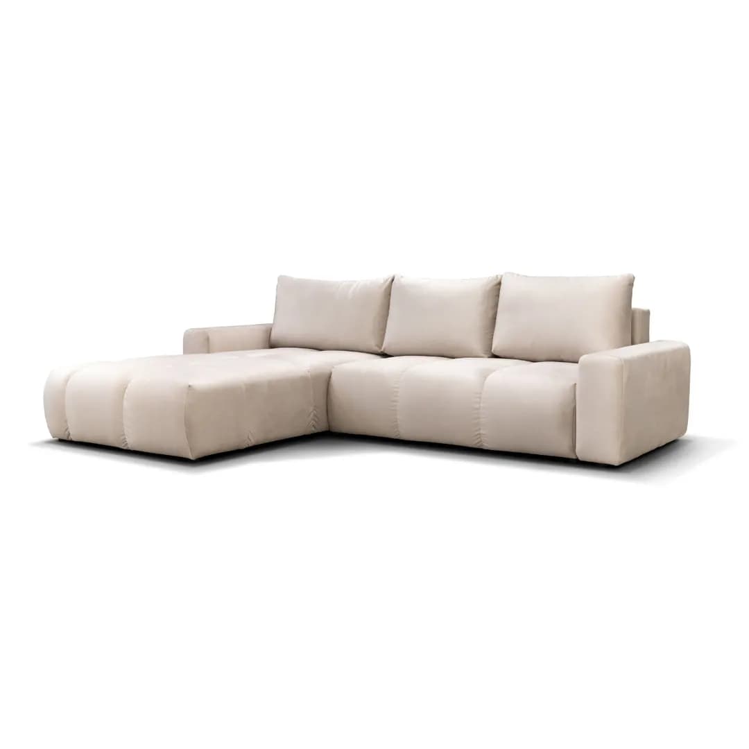 A contemporary L-shaped sectional sofa upholstered in a light beige or cream fabric. The sofa features a low-profile design, wide block arms, and deep, plush seating cushions. It consists of a main sofa section and an integrated chaise lounge on the left side, providing ample seating and lounging space. The modular appearance is enhanced by stitched seams defining individual seat blocks. — 3D model
