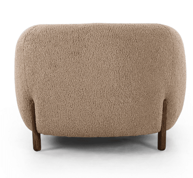 A contemporary, fully upholstered lounge chair with a rounded, organic form, covered in a textured, light beige boucle fabric and supported by short, dark cylindrical wooden legs. — 3D model