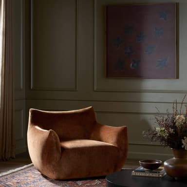 A contemporary lounge chair featuring a distinctive barrel-shaped silhouette, upholstered in a rich, reddish-brown velvet fabric. The chair is characterized by its deep, plush seating and integrated, low-profile armrests and backrest, which form a continuous, enveloping curve, suggesting substantial comfort and a modern aesthetic. It lacks visible legs, appearing to rest directly on a recessed base. — 3D model