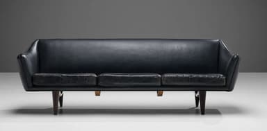 A three-seater sofa with a curved backrest and armrests, upholstered in dark leather. The seat is composed of three distinct cushions. The sofa is supported by four tapered wooden legs. — 3D model
