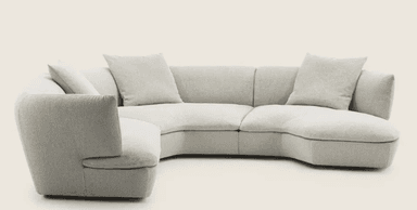 A sectional sofa with a curved, modular design, upholstered in a light-colored, textured fabric. The sofa features multiple seating sections and detached cushions for comfort. It is arranged in a semi-circular configuration, suggesting it is designed for a corner or open-plan space. — 3D model
