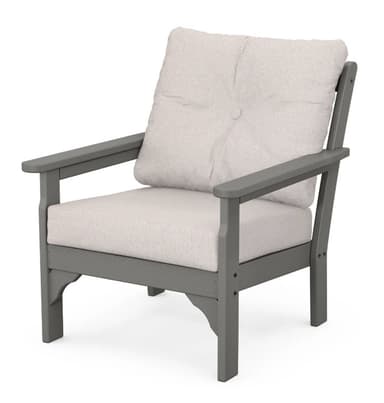 A gray outdoor armchair with a slatted backrest and upholstered seat and back cushions. The armchair features wide armrests and is constructed from a durable, weather-resistant material. It is designed for comfort and durability in an outdoor setting. — 3D model