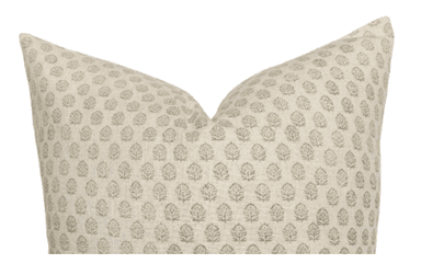 A close-up view of a plump throw pillow featuring a repeating botanical print pattern. The fabric is a light, textured woven material, possibly linen or a linen blend, in a cream or off-white base color. The pattern consists of stylized leaf or floret motifs in a muted beige or light brown hue, arranged in a grid-like fashion across the surface of the pillow. — 3D model