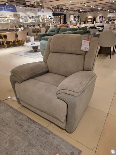 A contemporary upholstered recliner chair featuring a two-tone fabric design. The main body is covered in a light beige, textured fabric, while the lower frame and parts of the armrests are accented with a slightly darker, plain beige or light brown fabric. The chair has plush, padded cushioning on the seat, backrest, and armrests, indicating comfort and support. It appears to be in excellent, new condition. — 3D model