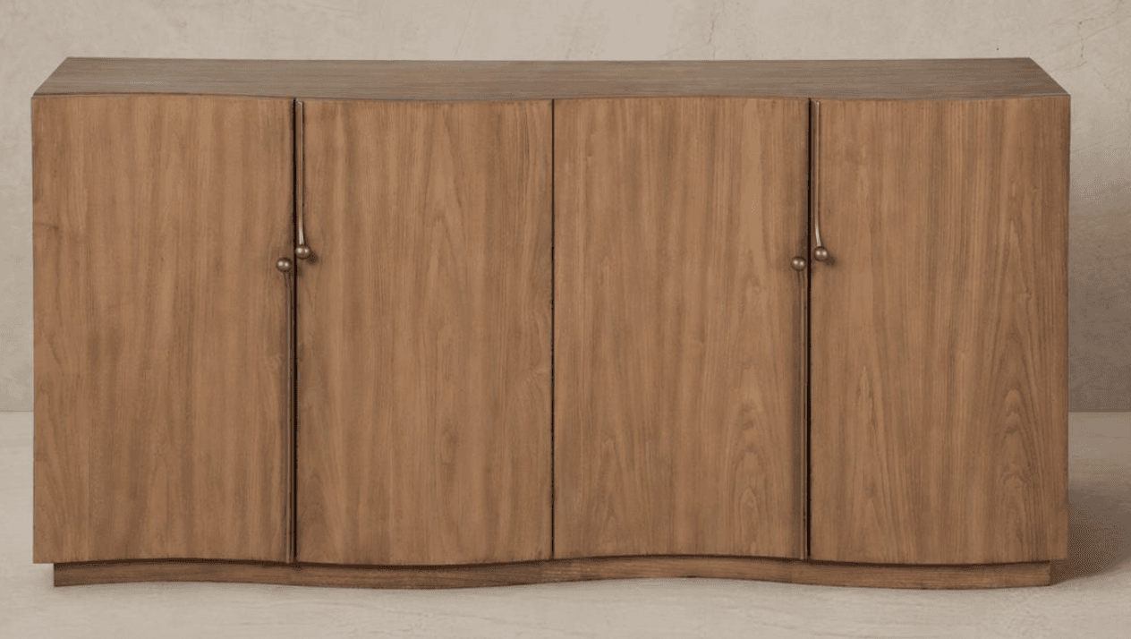 A long, low wooden cabinet featuring a serpentine or wave-like curved front. It has multiple doors, each adorned with a distinctive brass pull handle. The wood displays a natural grain pattern. — 3D model