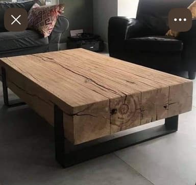 A rustic industrial coffee table featuring a thick, rectangular slab of natural wood as its top, supported by a minimalist black metal base. The wood displays prominent grain, natural cracks, and imperfections, suggesting a distressed or reclaimed character. The metal base consists of two 'U'-shaped frames, providing a sturdy, open support structure. — 3D model