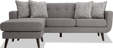 A contemporary gray fabric sectional sofa featuring a reversible chaise lounge. The sofa has clean lines, rounded armrests, and is supported by splayed, tapered dark wooden legs. The backrest includes subtle button tufting, and it comes with multiple loose back cushions and two patterned throw pillows. — 3D model