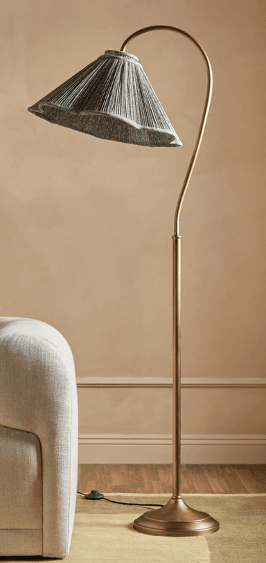 An elegant floor lamp featuring an antique brass finish, a slender, curved arc arm, and a pleated conical textile shade in a greenish-grey hue. The lamp stands on a weighted, stepped round base, providing stability and a classic aesthetic. — 3D model