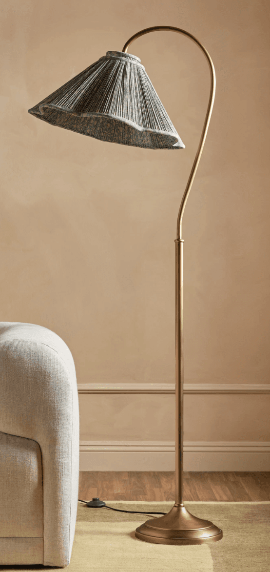 An elegant floor lamp featuring an antique brass finish, a slender, curved arc arm, and a pleated conical textile shade in a greenish-grey hue. The lamp stands on a weighted, stepped round base, providing stability and a classic aesthetic. — 3D model