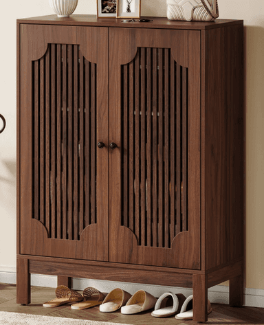 A two-door cabinet with vertical slat detailing on the doors and a decorative scalloped top edge. It stands on four straight legs and has two small, dark knobs as handles. — 3D model