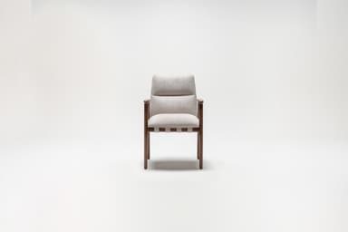 A side profile view of a mid-century modern armchair against a plain white background. The armchair features a wooden frame with dark brown legs and armrests. The seat and back are upholstered in a light-colored textured fabric. — 3D model