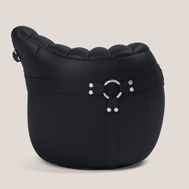 A barrel-shaped upholstered furniture piece, functioning as an ottoman or pouf, covered in black textured material, likely leather or faux leather. It features horizontal strap detailing with silver-toned rivets and D-rings or buckles, adding a decorative and somewhat rugged aesthetic. The top surface appears slightly cushioned. — 3D model