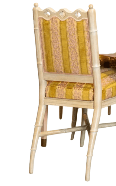 A side chair with a light-colored, possibly painted wooden frame. The frame features faux bamboo turnings on the legs and structural elements, with decorative carvings at the top of the backrest. The seat and backrest are upholstered with fabric that has a pattern of alternating wide golden yellow stripes and narrower stripes with a floral or damask-like motif in a darker pinkish-red and yellow. The upholstery appears to be velvet or a similar textured fabric. — 3D model