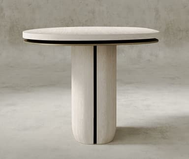 A contemporary pedestal accent table featuring a light-toned wooden finish and a distinctive design. The table has an organic, subtly oval-shaped tabletop with a layered edge, revealing a slim metallic accent layer beneath the main surface. The tabletop rests upon a substantial, rounded pedestal base, also crafted from the same light wood, which exhibits visible vertical grain. The base has a smooth, curved form that widens slightly at the bottom, creating a stable foundation. The overall aesthetic is minimalist and modern, with natural textures. — 3D model