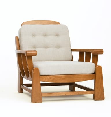A sturdy, craftsman-style lounge chair featuring a solid oak wood frame and thick, upholstered cushions. The chair has broad, rounded arms, slatted side panels, and block legs. The back cushion is button-tufted. — 3D model