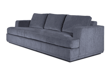 A contemporary upholstered sofa, viewed from the rear-right angle, featuring clean lines and a substantial form. It is covered in a textured slate gray fabric, presenting a modern aesthetic. The design includes thick, squared-off track arms and loose, plush back cushions. The sofa sits on a recessed plinth base, giving it a slightly floating appearance. The overall condition appears new and well-maintained. — 3D model