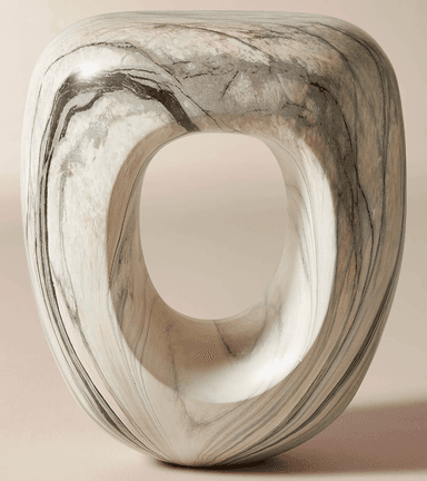 A modern sculptural accent table or stool crafted from a single piece of marble. It features an organic, curvilinear form with a prominent central elliptical void. The marble exhibits natural white, grey, and black veining patterns across its smooth, polished surface. — 3D model