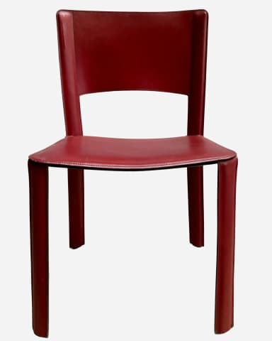 A modern, armless chair with a minimalist design. The seat and backrest are upholstered in a continuous piece of material that wraps around the frame. The chair features a cutout in the backrest for a modern aesthetic. The legs are straight and integral to the overall structure. Visible stitching around the edges of the seat and backrest indicates careful construction. — 3D model