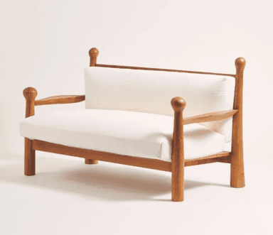 A wooden loveseat featuring a solid wood frame with distinctive turned posts at each corner, topped with spherical finials. It includes thick, removable seat and back cushions upholstered in white fabric. The armrests are open slats, and the entire piece rests on sturdy, straight legs. — 3D model