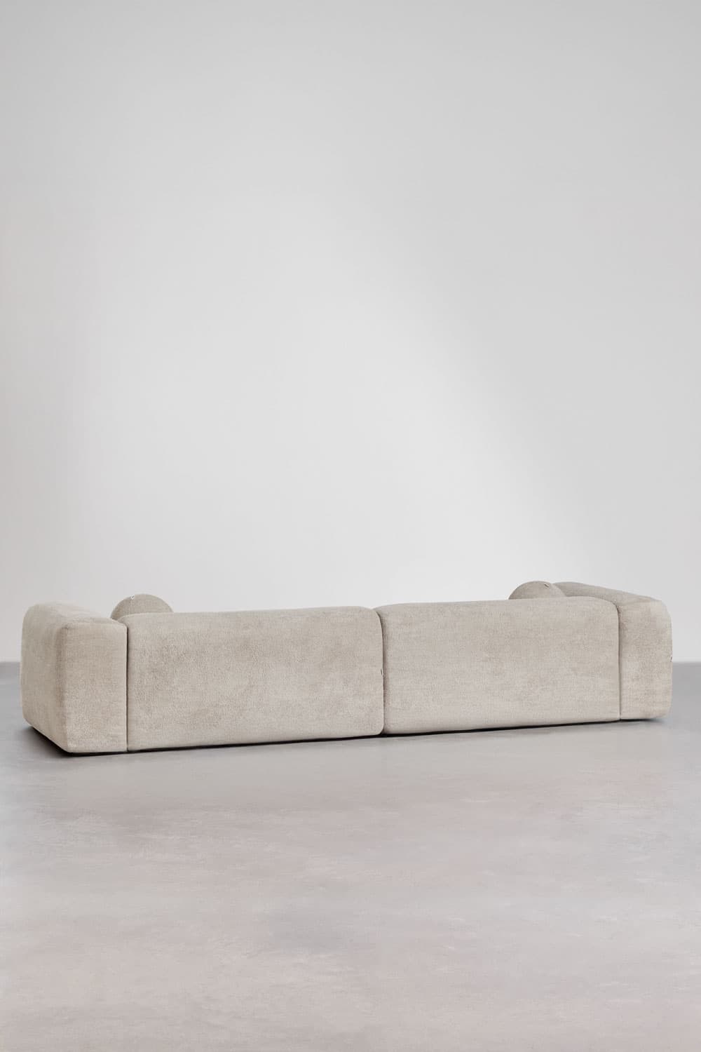 A contemporary, low-profile modular sofa upholstered in a light cream textured fabric, featuring soft, rounded edges and a minimalist design. — 3D model