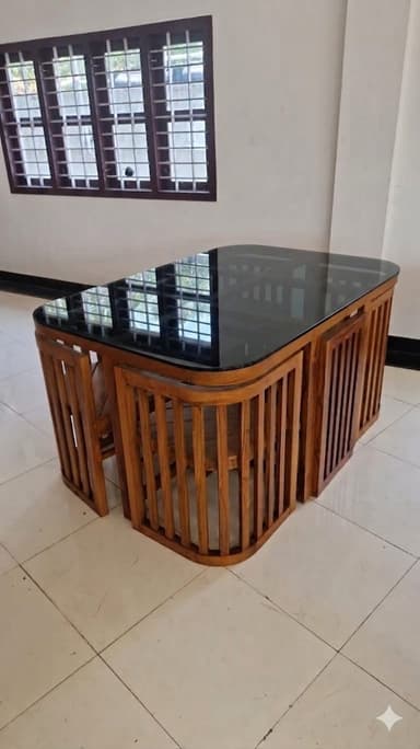 A rectangular coffee table with rounded corners. The base is constructed from vertical wooden slats arranged in a curved, slatted enclosure around the lower portion. The tabletop appears to be a dark, possibly glass or lacquered wood surface, with a smooth finish and slightly beveled edges. — 3D model