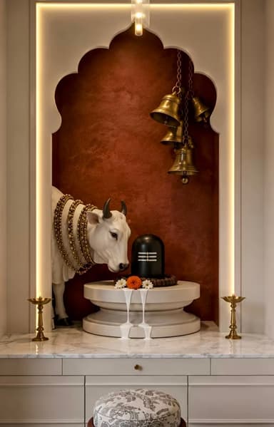 An integrated modern Hindu home temple unit, featuring a multi-tiered design with a marble countertop, storage drawers, and an arched spiritual niche. The niche houses religious artifacts including a Nandi statue and a Shiva Lingam, accented by brass bells and oil lamps. The unit is illuminated with integrated LED lighting along the arch and a delicate pendant light fixture. — 3D model