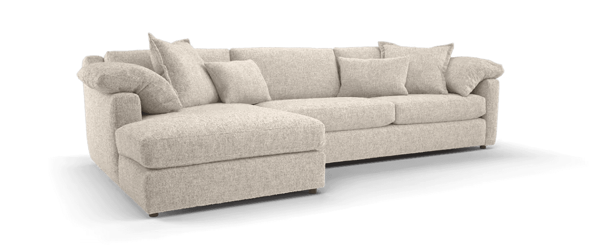 A sectional sofa with a chaise lounge. The sofa is upholstered in a light-colored, textured fabric and features deep seating with plush cushions. It has a modular design, allowing for various configurations. The arms are rounded and substantial, and decorative throw pillows are included. — 3D model