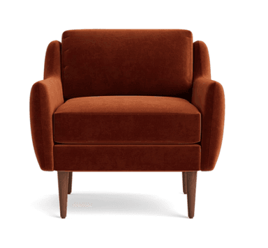 A contemporary armchair upholstered in a rich burnt orange velvet fabric. It features a boxy silhouette with slightly angled, wide arms that flow into the backrest. The armchair has a loose seat cushion and a separate back cushion, both generously padded. It stands on four slender, tapered wooden legs with a medium-dark finish. The design suggests a blend of modern and mid-century aesthetics. — 3D model