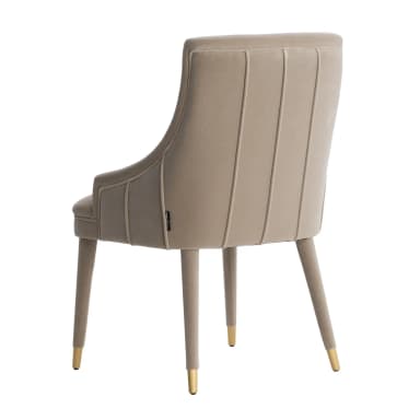 An upholstered armchair, seen from the rear, featuring a high back with vertical channel tufting. The chair is covered in a smooth, light beige or taupe velvet-like fabric. It has low, integrated armrests. The legs are slender, tapered, and wrapped in the same fabric, with gold-finished caps on the feet. — 3D model