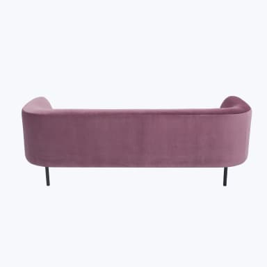 A pink velvet sofa with a curved back and arms, featuring a single seat cushion and a slender black base with four legs. — 3D model