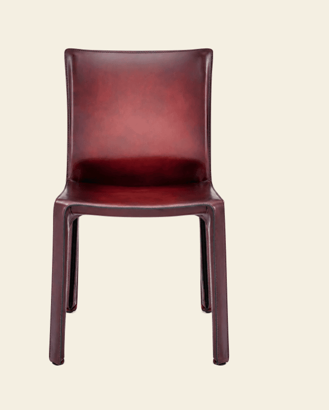 A modern dining chair fully upholstered in a rich burgundy leather, featuring a sleek, minimalist design with a monobloc appearance where the frame is completely covered. — 3D model