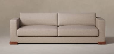 A two-seater sofa upholstered in light beige fabric, featuring straight, boxy track arms, two distinct seat cushions, two matching back cushions, and low rectangular wooden block feet. — 3D model