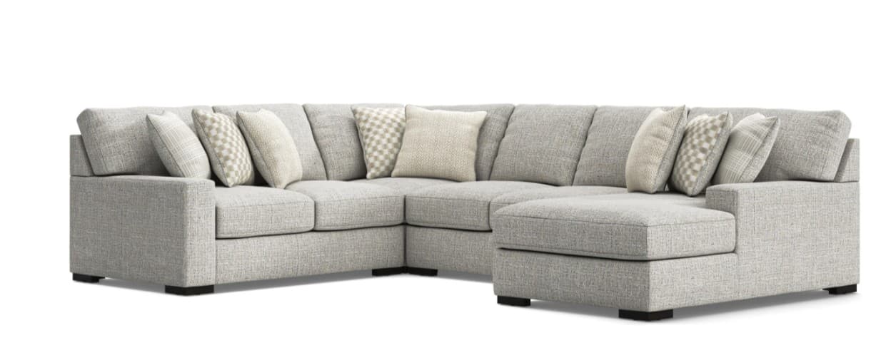 An L-shaped sectional sofa with a right-hand facing chaise, upholstered in a light gray textured fabric. It features clean lines, track arms, and multiple loose seat and back cushions, accompanied by several toss pillows. — 3D model