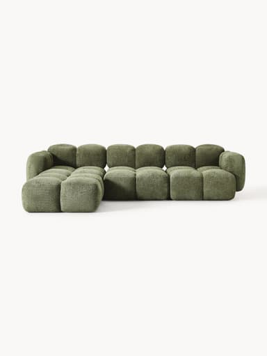 A modular sectional sofa composed of multiple cubic upholstered units. The sofa features a low profile and rounded edges on each module, creating a soft, organic aesthetic. It is upholstered in a textured, boucle-like fabric in a muted green hue. The arrangement suggests a configuration that includes a corner section and extended seating. — 3D model