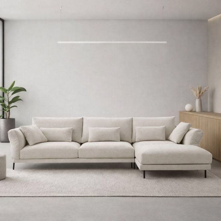 A modern L-shaped sectional sofa featuring an integrated chaise lounge, upholstered in a light beige textured fabric, and supported by slim black metal legs. — 3D model