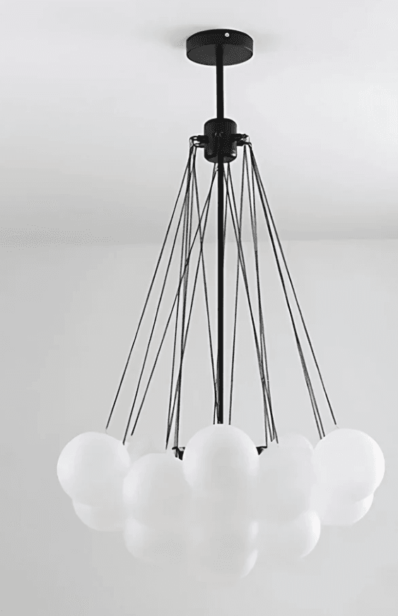 A modern chandelier featuring a black metal frame with multiple thin suspension wires supporting a circular frame. Attached to the circular frame are numerous spherical white glass shades, arranged in a cluster. The chandelier suspends from a central black rod connected to a ceiling mount. — 3D model