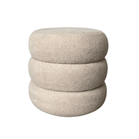 An off-white, cream-colored ottoman featuring a unique design composed of three stacked, rounded, cylindrical forms. It is upholstered in a textured bouclé fabric, giving it a soft and inviting appearance. The overall shape is sculptural and modern. — 3D model