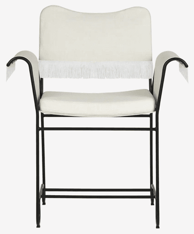 A contemporary armchair featuring a minimalist black metal tubular frame and upholstered seat, back, and armrests. The upholstery is off-white or cream-colored fabric, and the armrests are adorned with a distinctive fringe detail. — 3D model