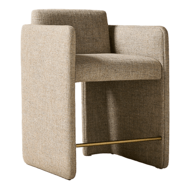 A contemporary armchair with a cubist-inspired design. It features a fully upholstered body with a textured, woven fabric in a neutral beige-brown hue. The armchair has high, straight armrests that extend down to form the sides of the base, creating a unified, solid form. A thin, cylindrical metal bar in a brass finish spans the width between the two side panels of the base, serving as a subtle structural element and footrest. The seat and back are well-padded, suggesting comfort. — 3D model