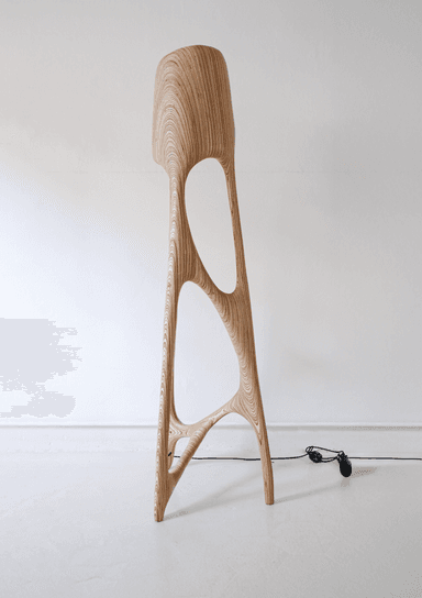 A modern bar stool with an organic, flowing design. It features a sculpted seat and backrest integrated into a single piece. The base consists of three legs that branch and curve outwards, creating open, abstract spaces. The material exhibits a strong wood grain pattern with concentric rings on the seat. — 3D model