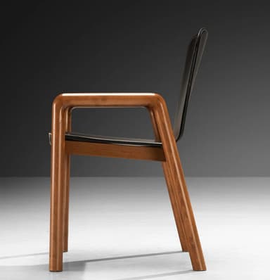 A modern armchair with a dark, possibly leather, seat and backrest, supported by a visible wooden frame. The armrests are integrated into the wooden structure and have a curved, rounded profile. The legs are straight and also made of wood. The overall design appears to be minimalist and functional. — 3D model