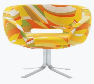 A modern accent chair with a rounded, low-profile backrest and seat. The upholstery features a vibrant, abstract geometric pattern in shades of yellow, orange, green, and white. It has an integrated armrest design and a central opening in the seat. The chair is supported by a brushed metal pedestal base with four splayed legs. — 3D model