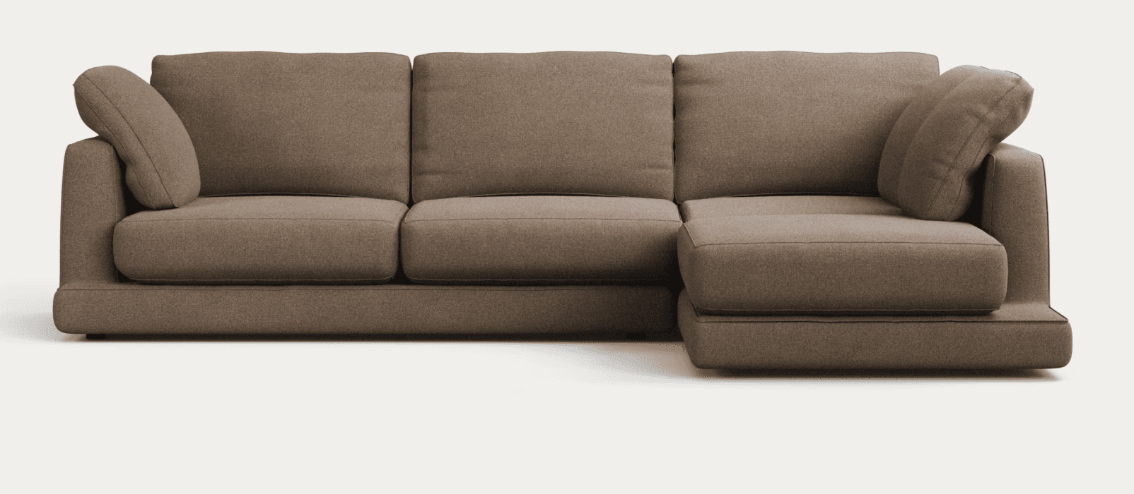 A modern sectional sofa upholstered in a light brown or taupe woven fabric. It features a main three-seat sofa module combined with a right-hand facing chaise extension, forming an L-shaped configuration. The design is minimalist with clean lines, subtly rounded edges on the cushions, and a low-profile base with concealed feet. It includes three back cushions, three seat cushions (two individual, one chaise), and two bolster-style accent pillows integrated into the arms. — 3D model