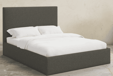 A contemporary platform bed fully upholstered in a dark gray fabric, featuring a rectangular headboard and a low-profile frame. The bed is presented with white bedding. — 3D model