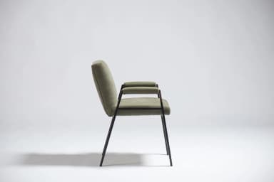 An armchair with a dark-colored frame and upholstered seat, back, and armrests in a light olive green fabric. The frame appears to be made of metal or a dark wood, with slender legs and arm supports. The upholstery has a textured weave. The design suggests a mid-century modern or contemporary aesthetic. — 3D model