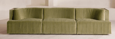 A contemporary sofa upholstered in a rich green velvet, featuring distinctive channel tufting across its backrest and seat. The sofa integrates a continuous wooden surface that serves as armrests and a functional back shelf, with sculpted cut-outs that conform to the upholstered backrest. — 3D model