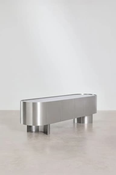 A contemporary sideboard with a sleek, elongated oval form. It features a brushed metal exterior with a series of vertical door panels and rests on two substantial, cylindrical pedestal legs, one at each end. The top surface appears smooth and continuous, possibly a different material or finish than the body. — 3D model
