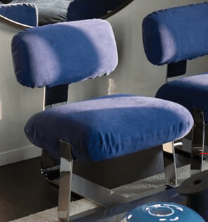 A modern, armless low-profile lounge chair featuring plush blue velvet-like upholstery and a polished chrome or stainless steel sled base. — 3D model