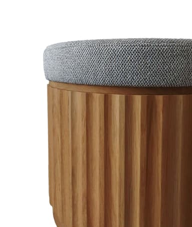 A contemporary round ottoman featuring a distinctive fluted oak wood base and a grey textured upholstered top. The wood grain is visible, and the fluted design adds a textural element to the base, while the fabric top provides a comfortable, cushioned surface. — 3D model