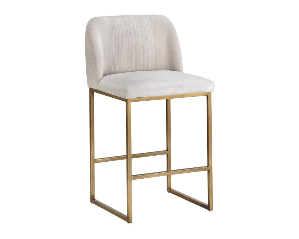 A contemporary bar stool featuring a cushioned seat and backrest upholstered in a light-colored textured fabric. The backrest has subtle vertical channel tufting. The stool is supported by a sleek, rectilinear metal frame in a brass or antique gold finish, with horizontal stretchers connecting the legs for added stability. The overall design suggests a modern aesthetic. — 3D model
